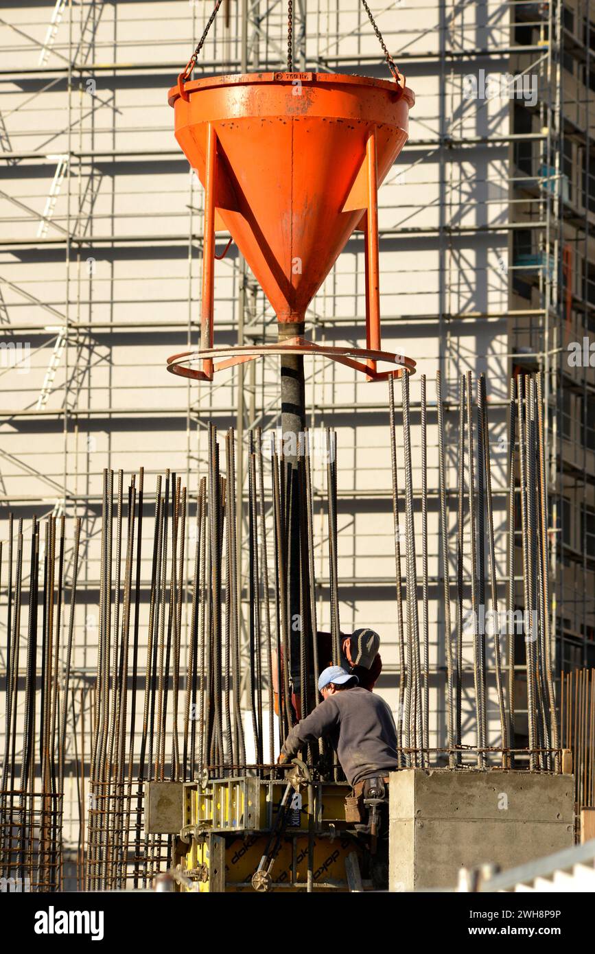 Baustelle, Bauarbeiter, Gießen von Betonmischungen, Bewehrungsformen, Gießen von Zementmischungen, Baustelle, Beruf, Fülltrichter Stockfoto