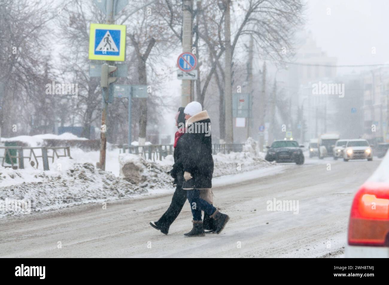 Starker Schneefall in Samara Fußgänger überqueren eine unbefestigte Straße während eines Schneefalls Samara Region Russland Copyright: XSvetlanaxVozmilovax Vozmilova4152 Stockfoto
