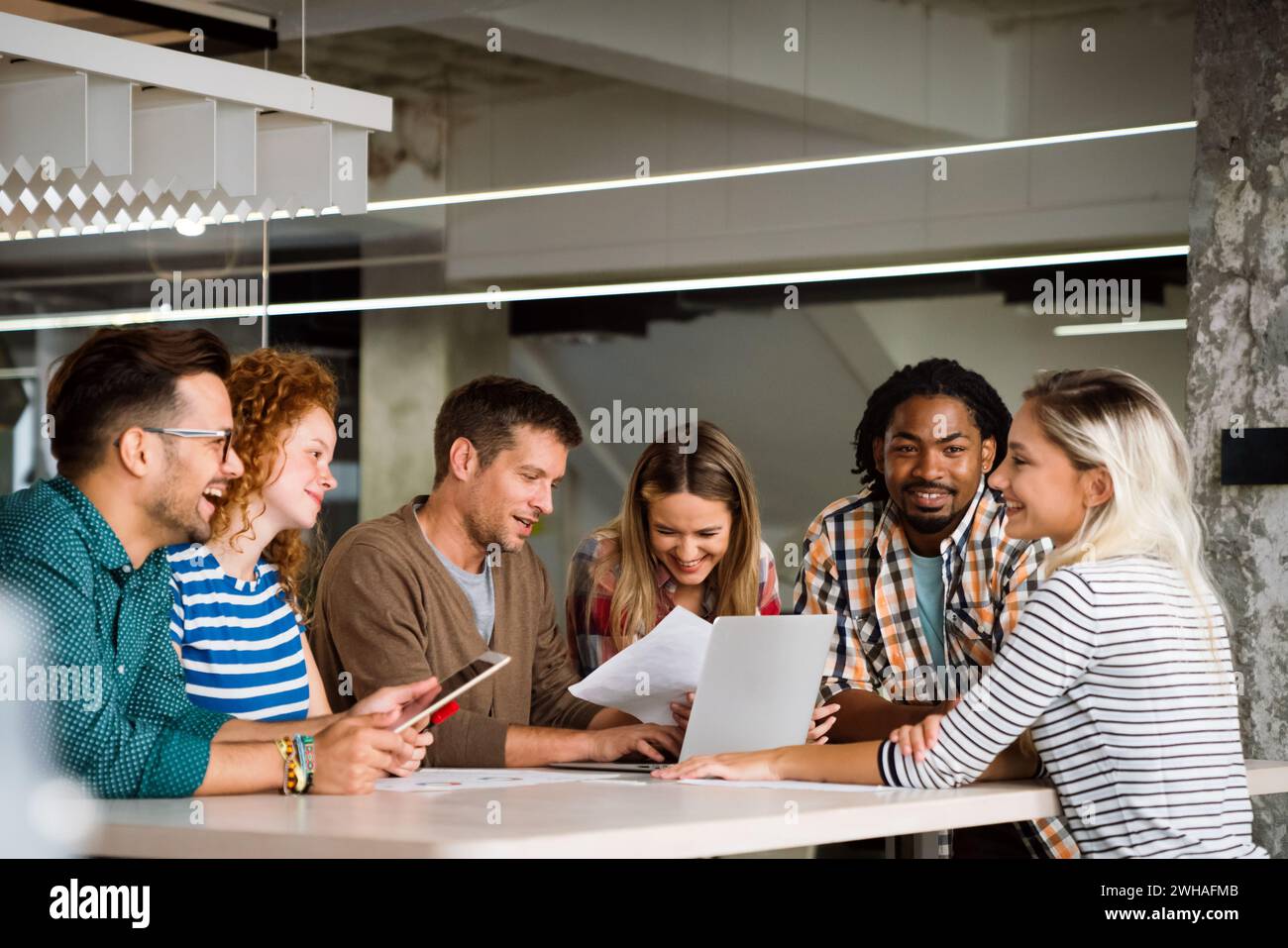 Verschiedene Kollegen aus dem Geschäftsbereich versammeln sich in einem Brainstorming, um Finanzstatistiken gemeinsam zu besprechen Stockfoto