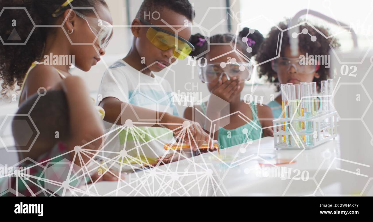 Bild von Elementardiagrammen über glückliche unterschiedliche Schüler im Chemiekurs Stockfoto