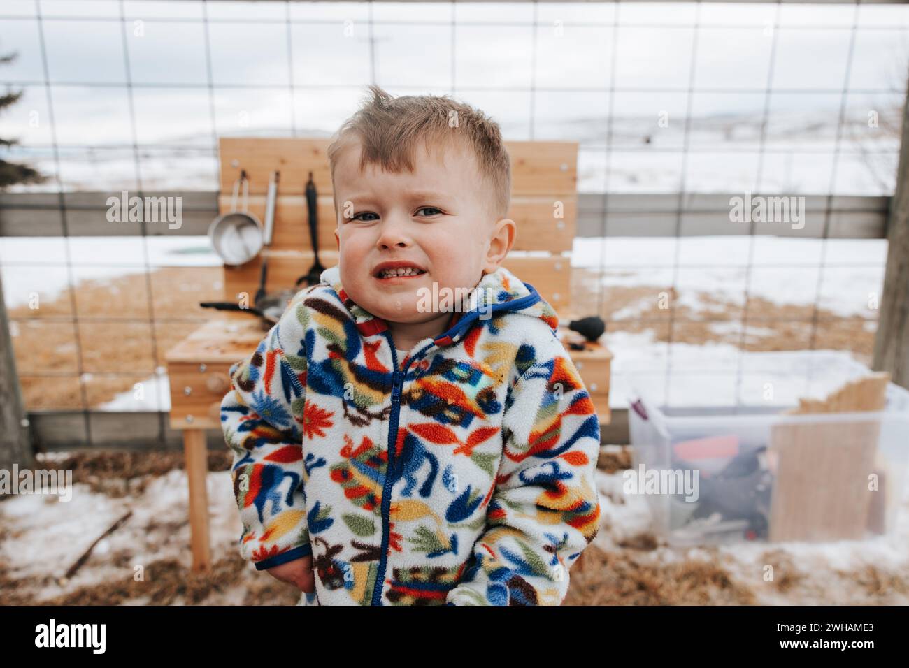 Lächelndes Kleinkind mit kalten Händen nach verschneiten Schlammspielen Stockfoto