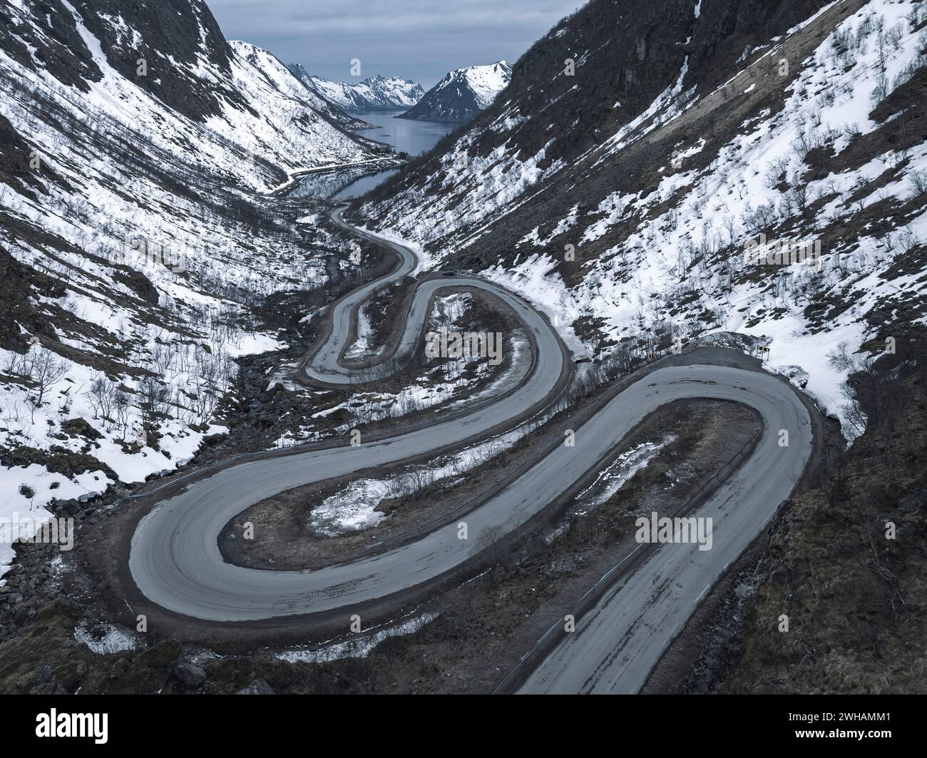 Drohnenaufnahme der kurvenreichen Straße auf schneebedeckten Bergen Stockfoto