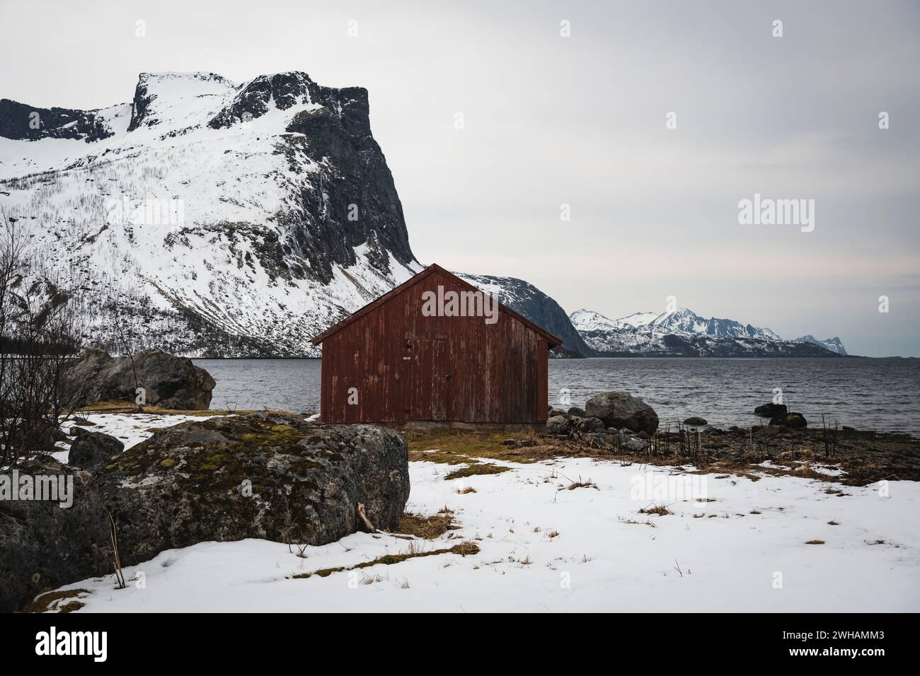 Holzhütte auf schneebedecktem Land auf dem Meer Stockfoto