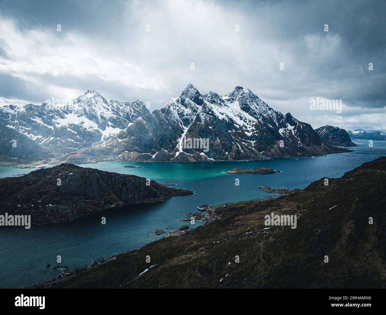 Drohnenschoss von Wolken über Bergen und Meer im Winter Stockfoto