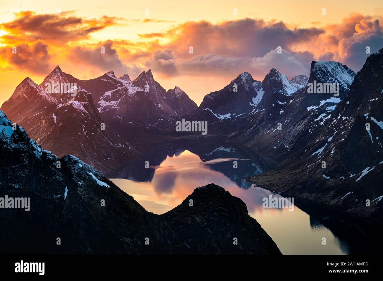 Malerischer Blick auf das Meer inmitten schneebedeckter Berge bei Sonnenaufgang Stockfoto