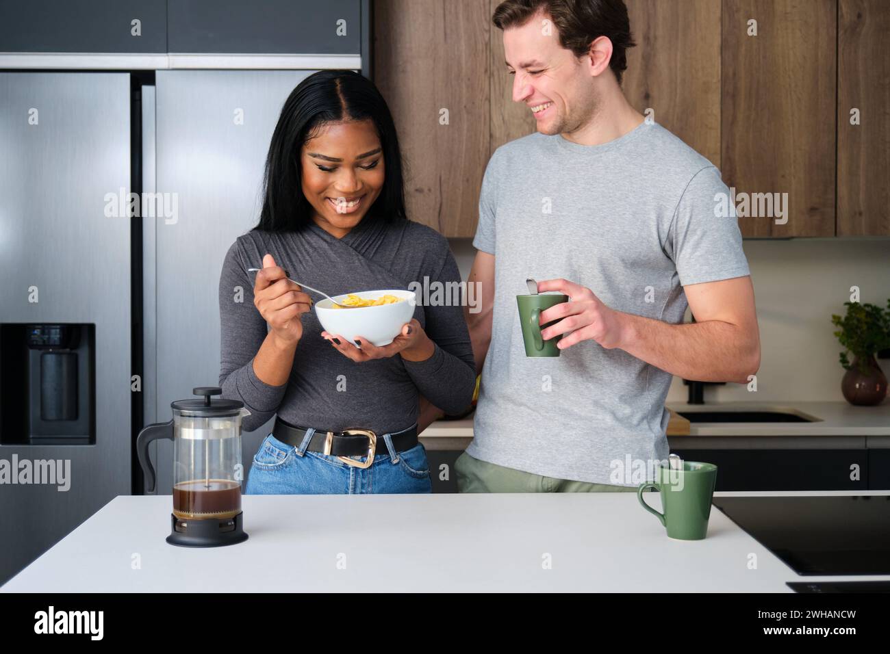 Multiethnisches Paar, das Spaß beim Frühstück in der Küche hat. Stockfoto
