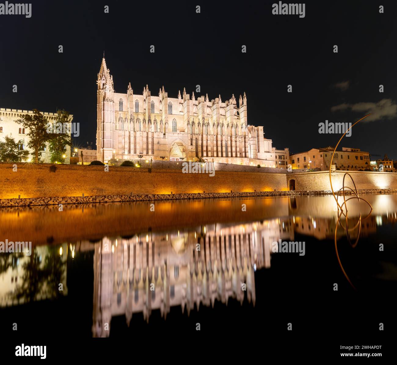 Palma de Mallorca, Spanien - 31. Januar 2024: Nächtlicher Blick auf die Kathedrale von Mallorca in der Innenstadt von Palma mit Reflexionen im Wasser Stockfoto