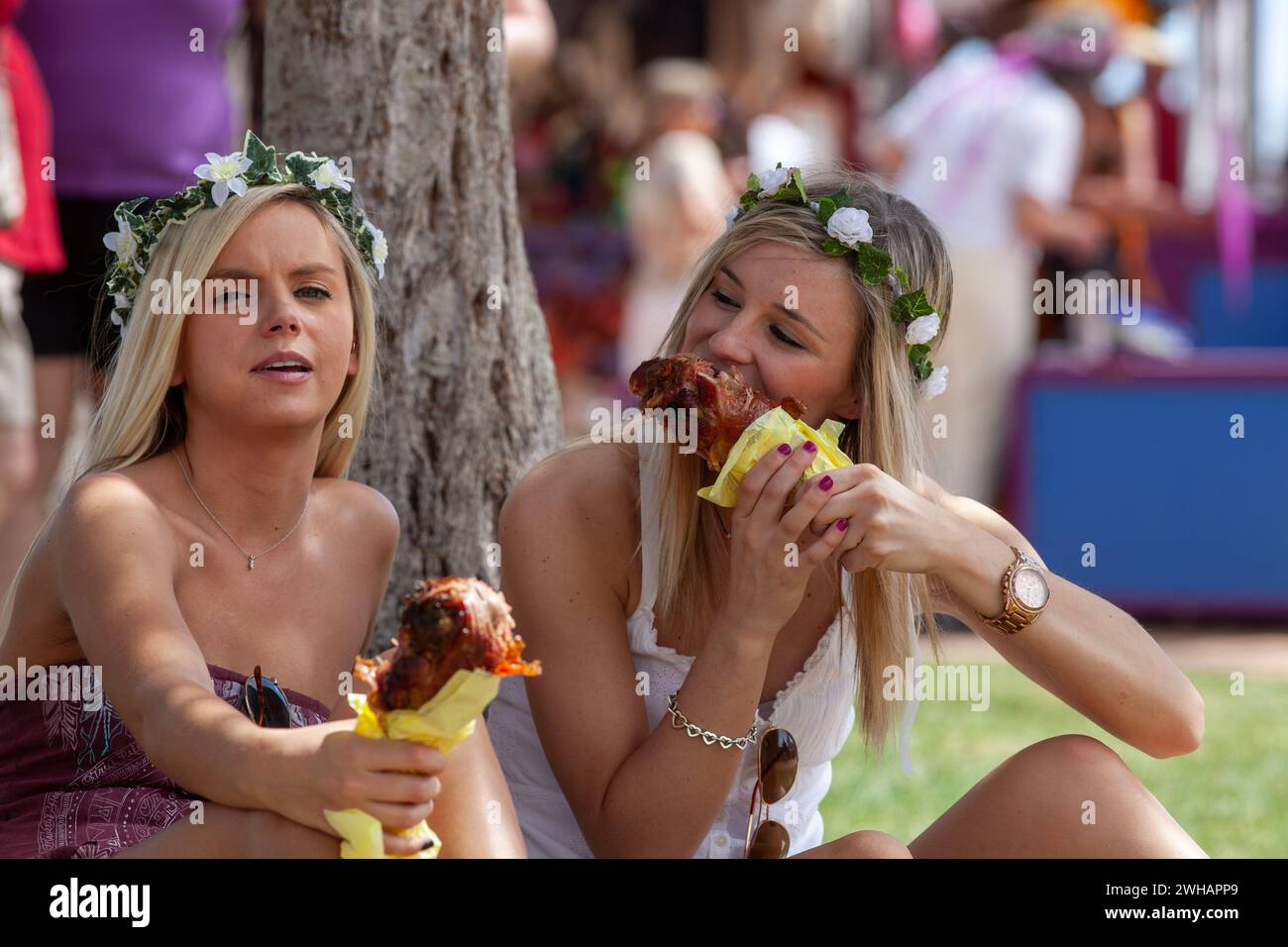 Zwei junge Damen essen truthahnbeine auf der Renaissance-Messe Stockfoto