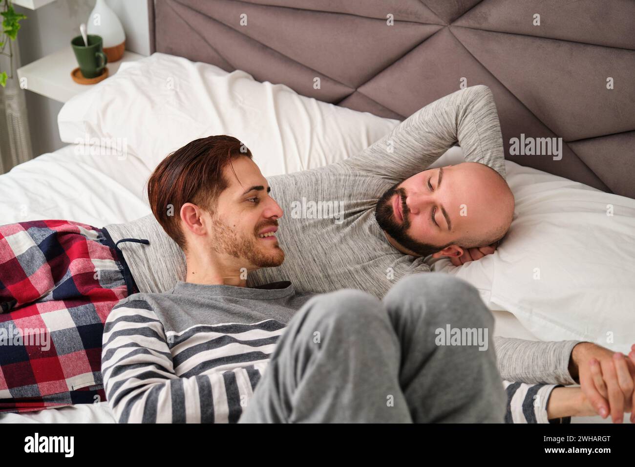 Homosexuelles romantisches Paar, das sich im Bett ansieht. Stockfoto