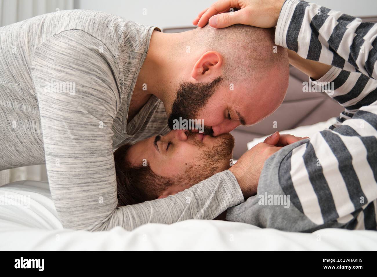 Homosexuelles romantisches Paar, das sich im Bett küsst. Stockfoto