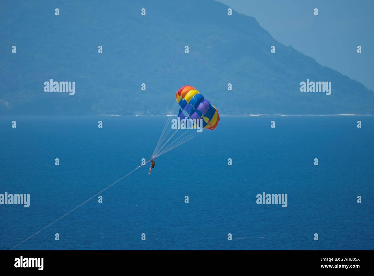 Gleitschirmfliegen für eine Person vom Boot am Beau vallon Beach, Mahe, Seychellen Stockfoto