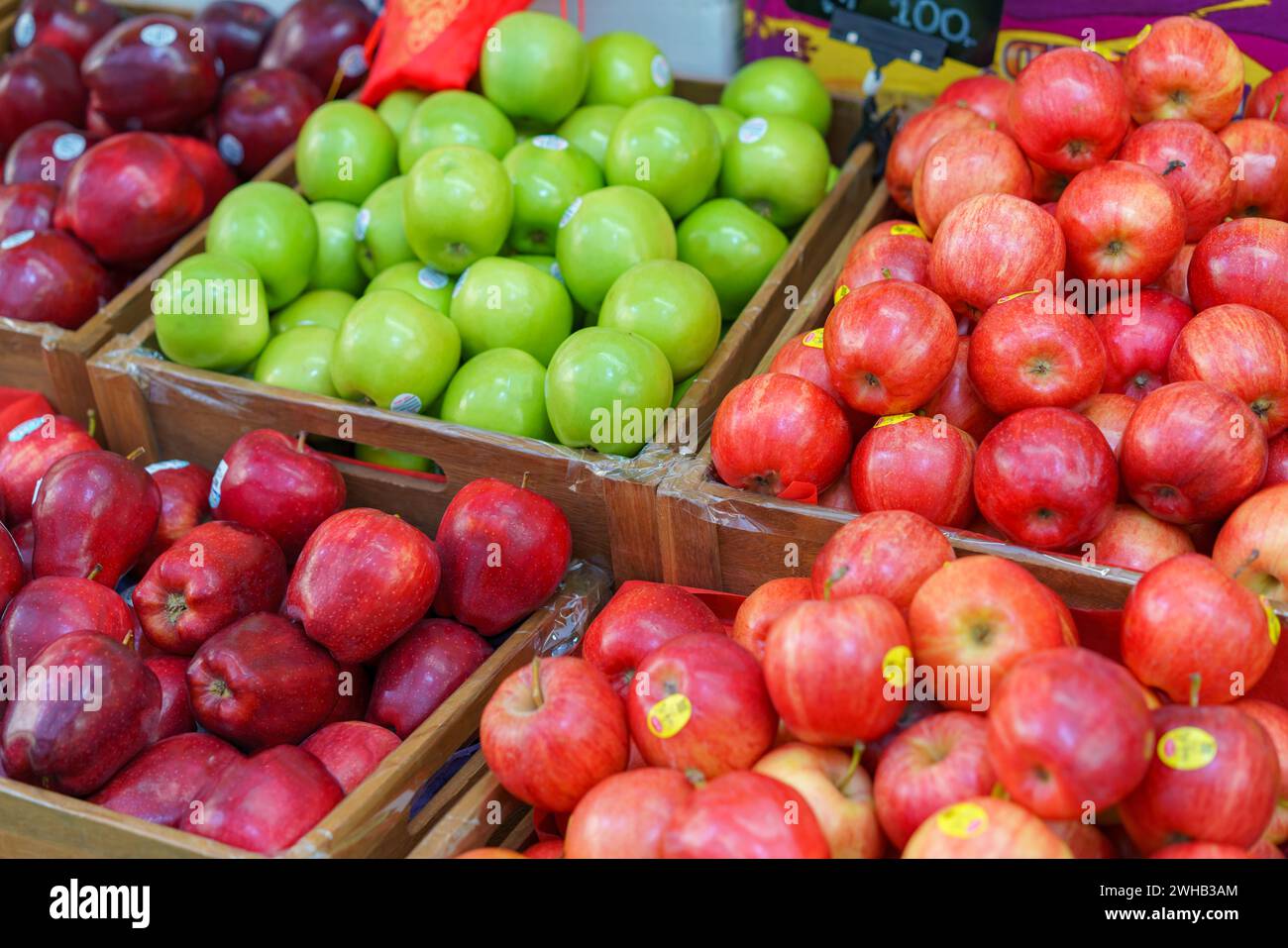 Holzkisten gefüllt mit einer Vielzahl von frischen roten und grünen Äpfeln auf einem lokalen Bauernmarkt, auf dem biologische und gesunde Produkte präsentiert werden Stockfoto