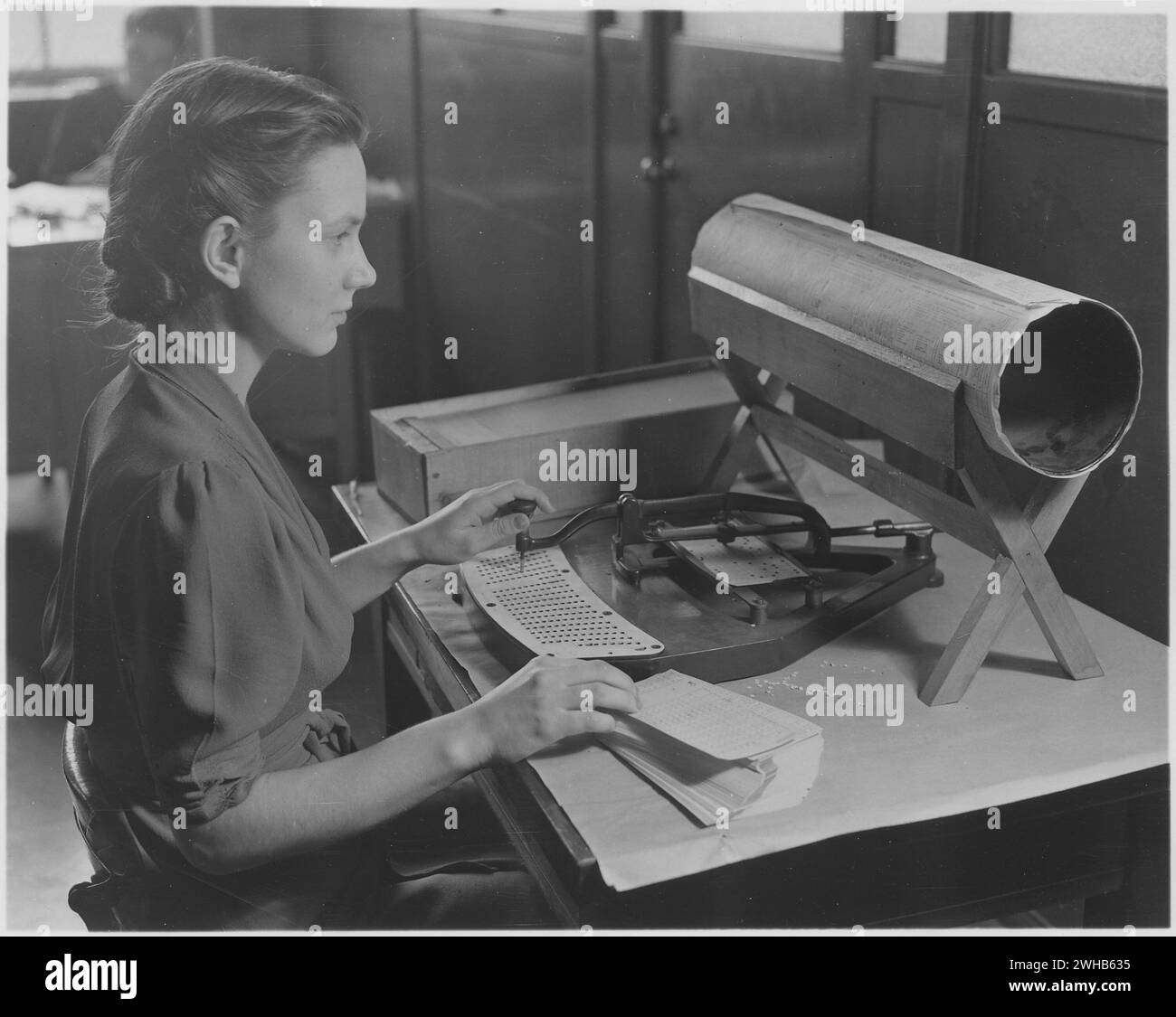 USA ca. 1950. Frau, die den Kartenpuncher bedient. Ein Card Puncher, ein integraler Bestandteil des Tabulationssystems, das vom United States Census Bureau verwendet wird, um Tausende von Fakten zu sammeln, die vom Bureau gesammelt wurden. Löcher werden in die Karte nach einem vorab vereinbarten Code eingestanzt, der die Fakten aus dem Erhebungsfragebogen in die Statistik überträgt." Stockfoto