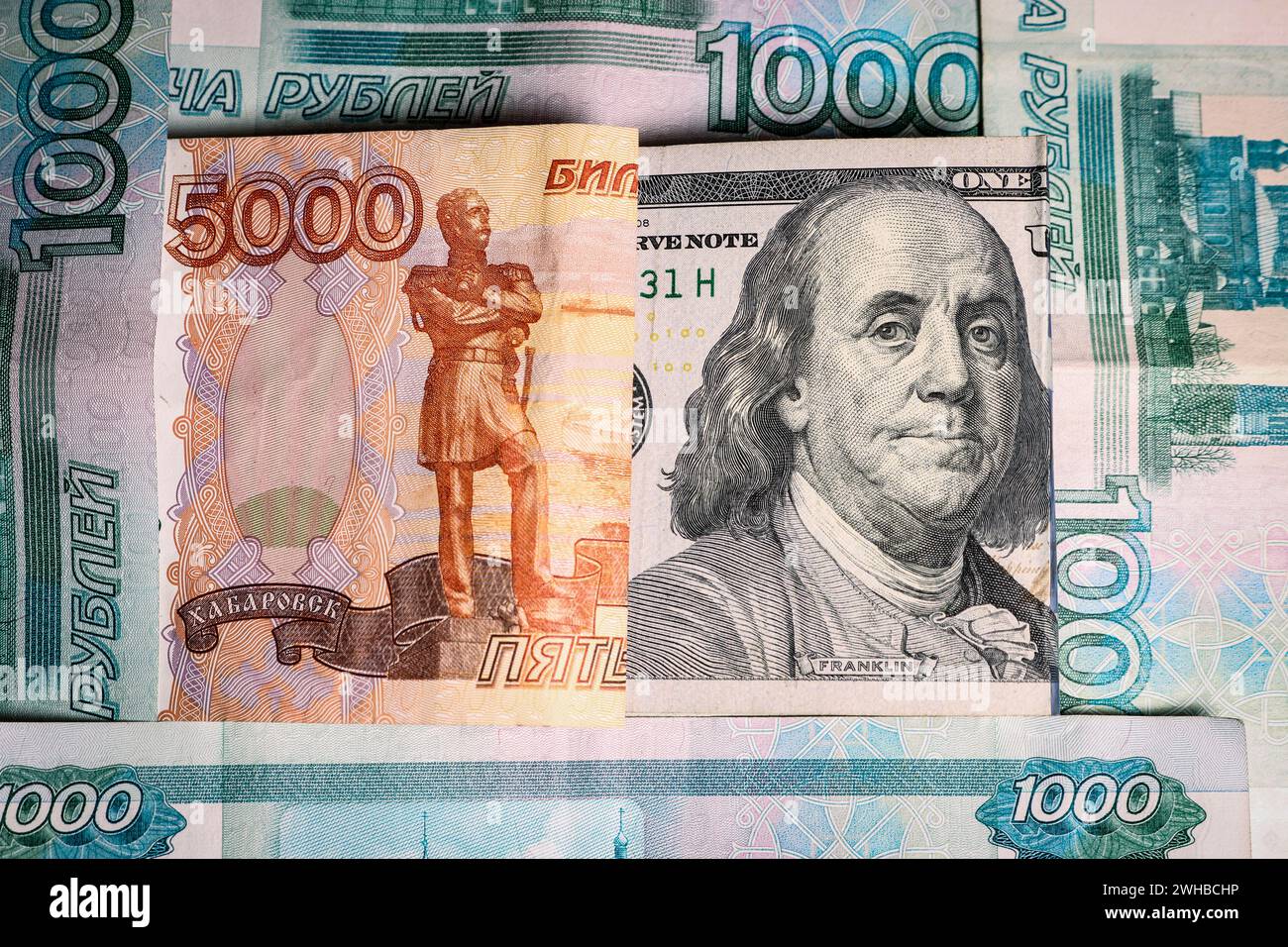 Ein Porträt des amerikanischen Präsidenten Franklin auf einer Banknote unter russischen Rubelscheinen. Stockfoto