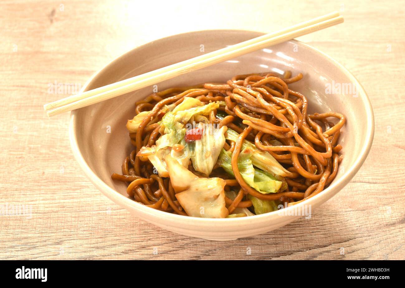 Gebratene japanische Yakisoba-Nudeln und Kohl in würziger Sauce auf einer Schüssel Stockfoto