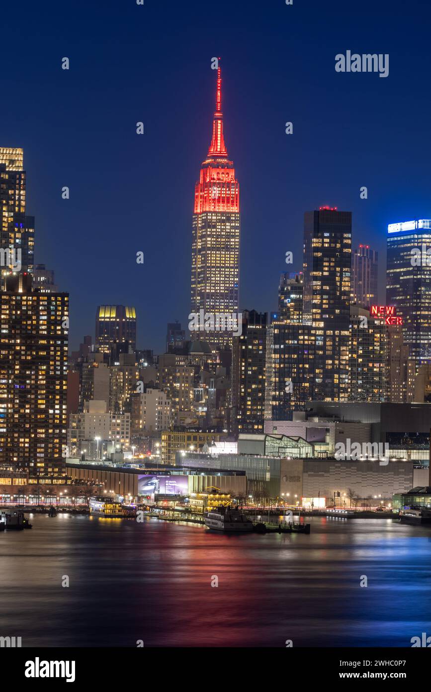 New York, USA. Februar 2024. Dieses am 8. Februar 2024 aufgenommene Foto zeigt das Empire State Building, das zum chinesischen Neujahrsfest in New York rot beleuchtet wurde. Das Empire State Building begann seine Mondneujahrsfeier am Donnerstag mit einer zeremoniellen Beleuchtung und der Enthüllung der Fifth Avenue Window Exhibition. ZUM BEISPIEL „New York Empire State Building glänzt rot für das chinesische Neujahrsfest“ Guthaben: Winston Zhou/Xinhua/Alamy Live News Stockfoto