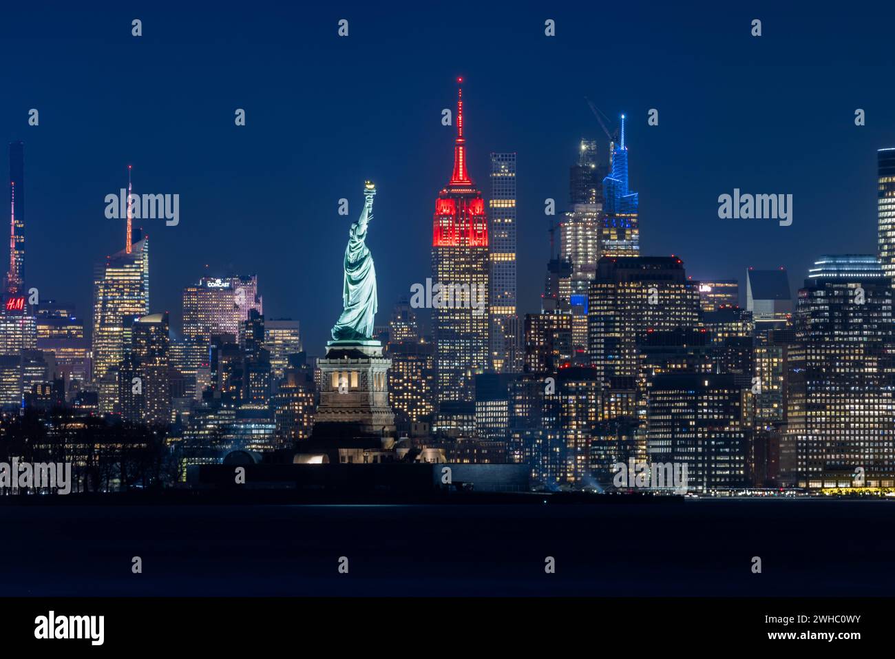 New York, USA. Februar 2024. Dieses am 8. Februar 2024 aufgenommene Foto zeigt das Empire State Building, das zum chinesischen Neujahrsfest in New York rot beleuchtet wurde. Das Empire State Building begann seine Mondneujahrsfeier am Donnerstag mit einer zeremoniellen Beleuchtung und der Enthüllung der Fifth Avenue Window Exhibition. ZUM BEISPIEL „New York Empire State Building glänzt rot für das chinesische Neujahrsfest“ Guthaben: Winston Zhou/Xinhua/Alamy Live News Stockfoto
