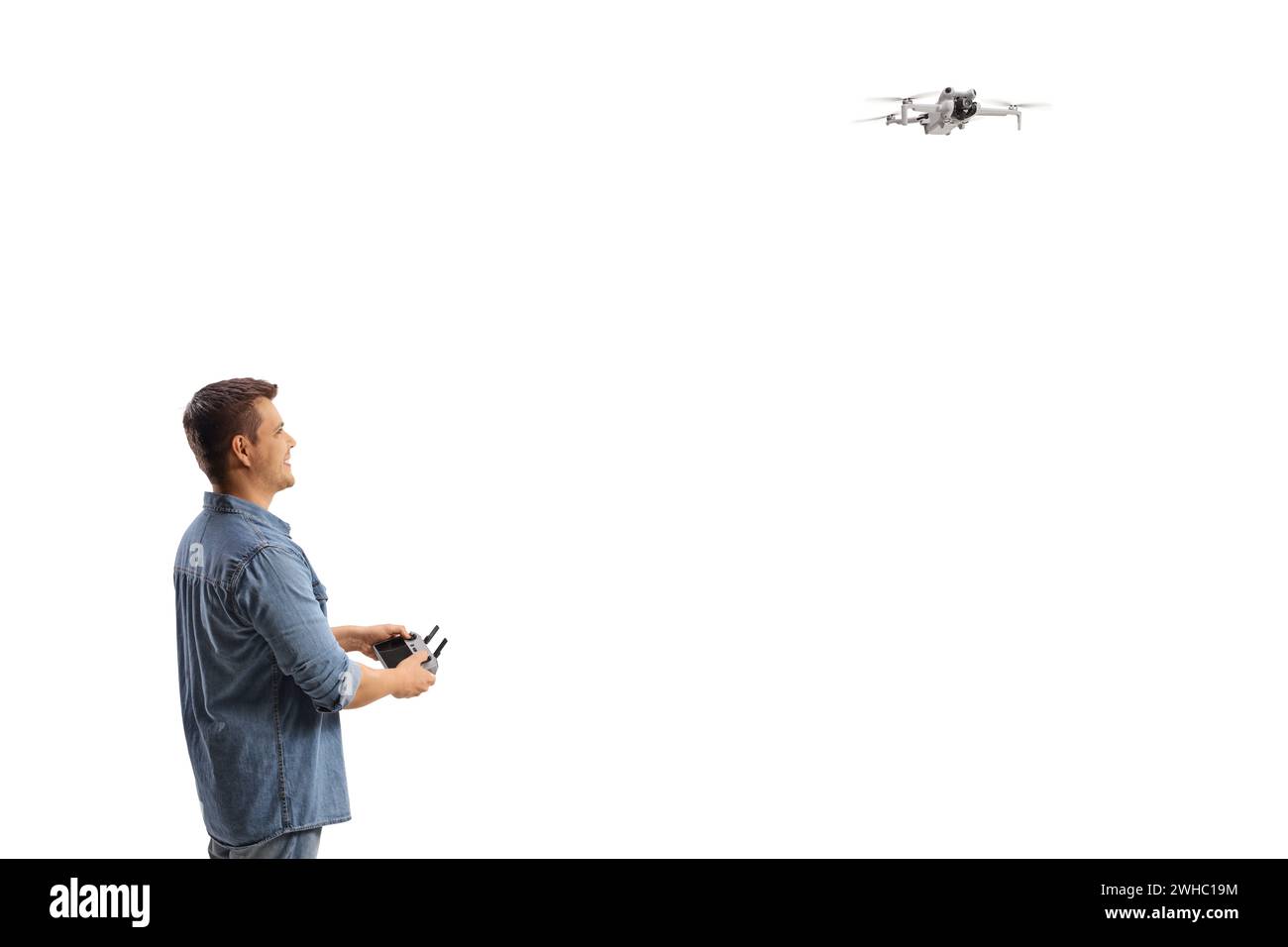 Ein Typ, der eine Drohne auf weißem Hintergrund fliegt Stockfoto