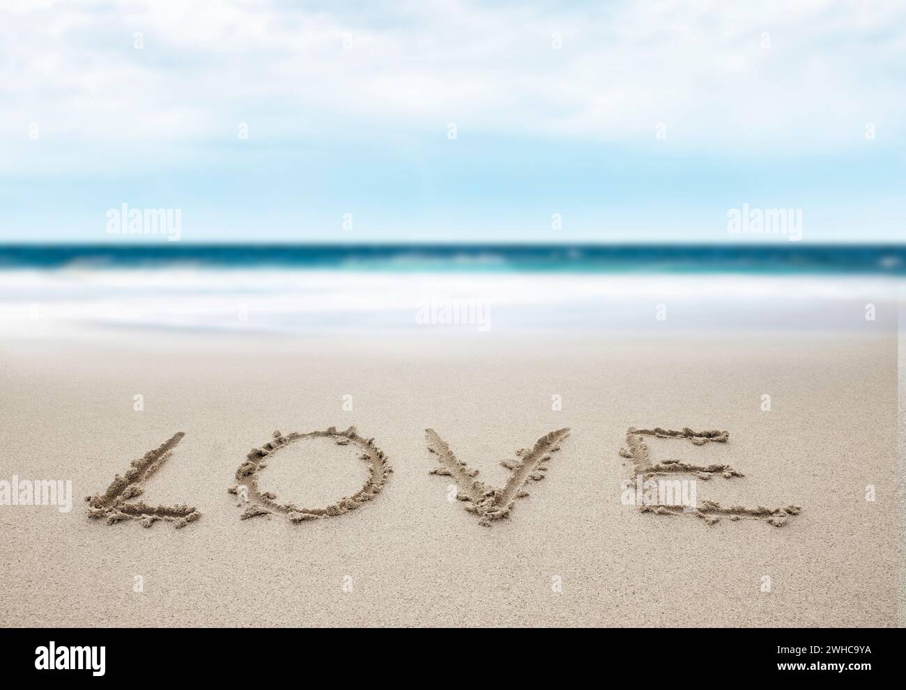 Schreiben Sie Liebe in Sand am Strand Stockfoto