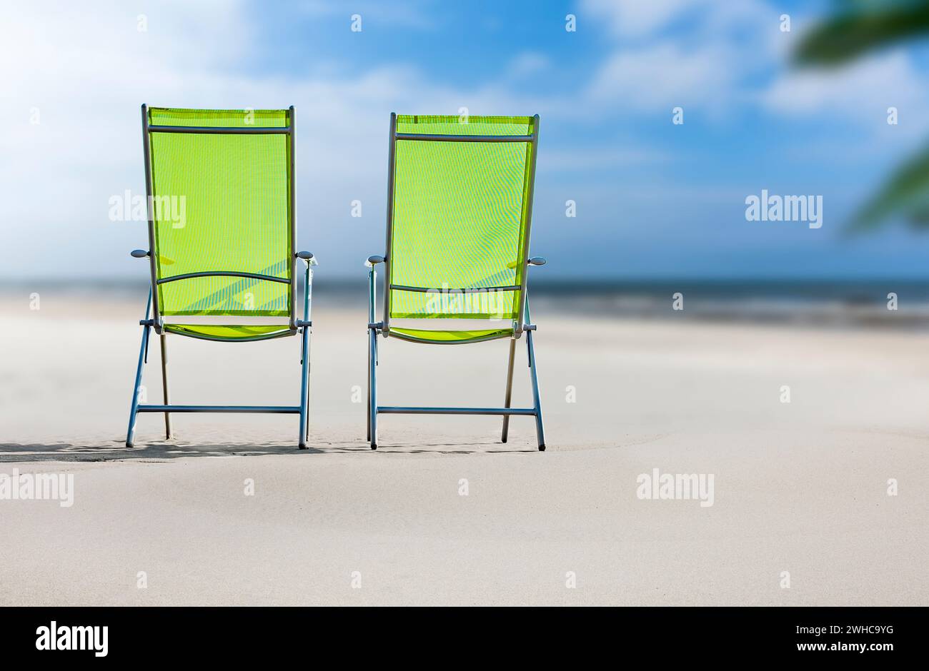 Grüne Liegestühle am Sandstrand Stockfoto