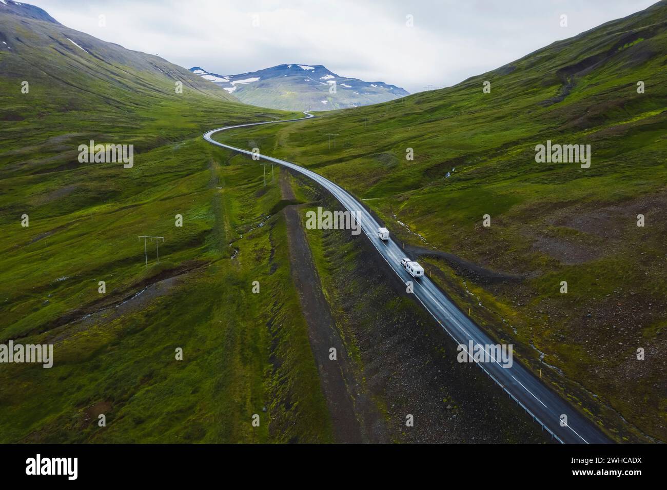 Autos fahren auf einer schönen abgelegenen Straße, Reisehintergrund, landschaftlich reizvolle Landschaft aus Island. Stockfoto