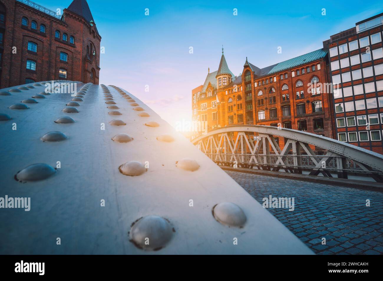 Perspektive der Eiserne Bogenbrücken in historischen Lagerhallen in Speicherstad Bezirk in Hamburg, Deutschland. Hintergrundbeleuchtung Sonne Licht Aufflackern. Stockfoto