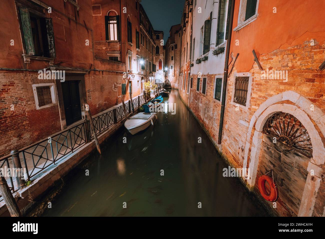 Venedig bei Nacht. Schmaler Kanal und Gondelboote in der Lagunenstadt venedig. Foto mit langer Belichtung. Stockfoto