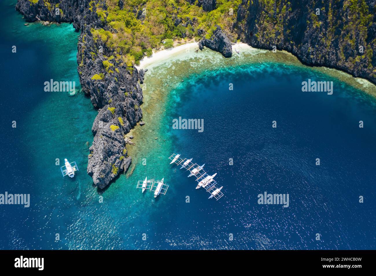 Blick aus der Vogelperspektive auf weiße Tauchboote vor Ort in der Nähe der tropischen Miniloc Island. El Nido, Insel Palawan, Philippinen. Stockfoto