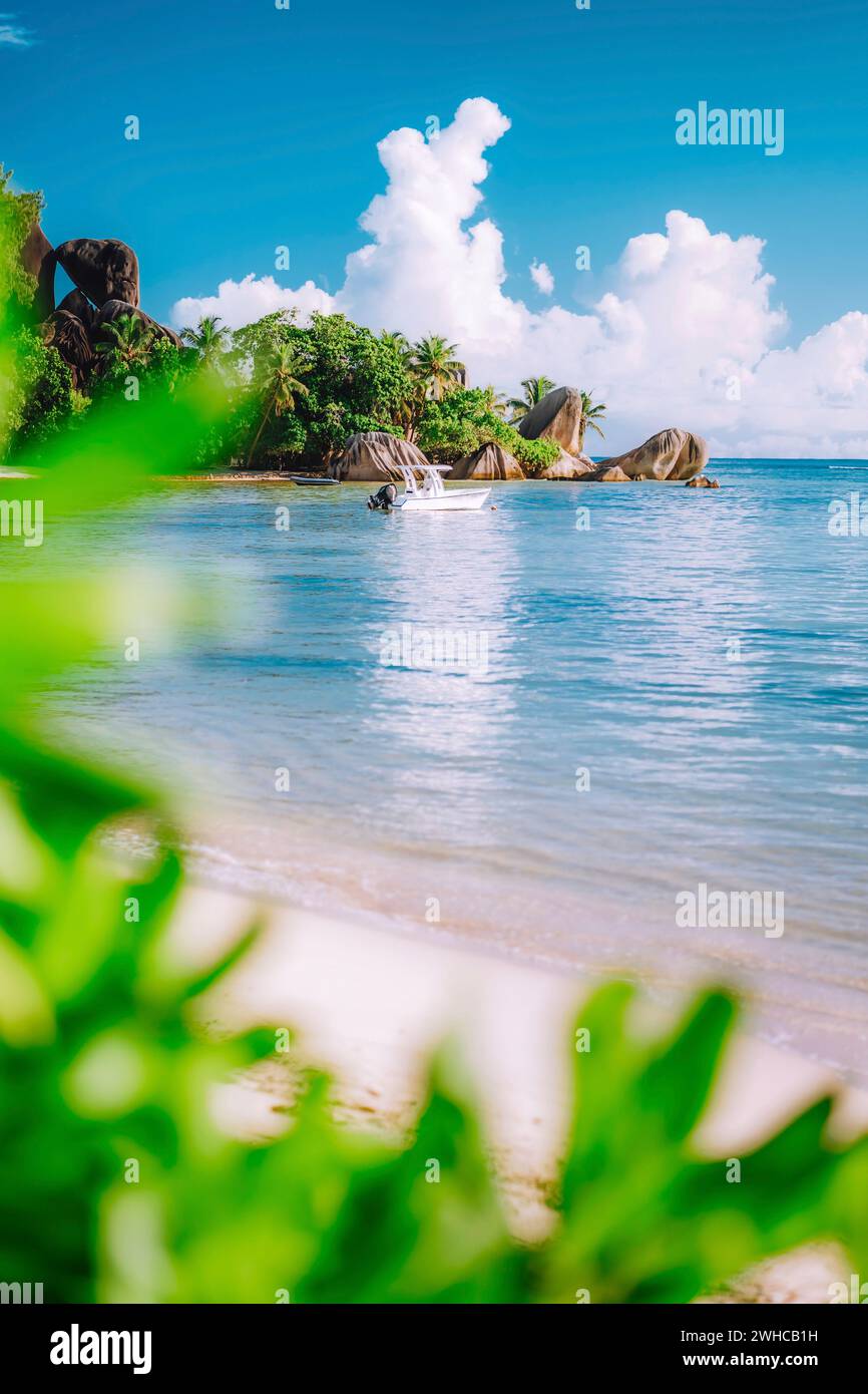 Laub gerahmtes Bild des berühmten Seychellen-Strandes Anse Source d'Argent. Bekannte Granitfelsen der Insel La Digue im Hintergrund. Stockfoto