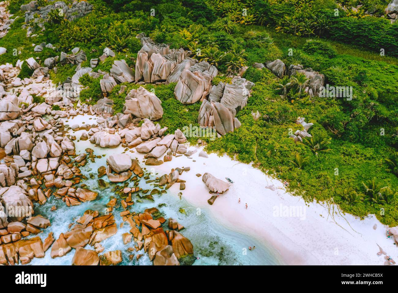 La Digue, Seychellen. Blick aus der Vogelperspektive auf den abgeschiedenen Strand, der im Dschungel versteckt ist. Weißer Sandstrand mit türkisfarbenem Meereswasser und malerischen Granitfelsen im tropischen Paradies. Stockfoto