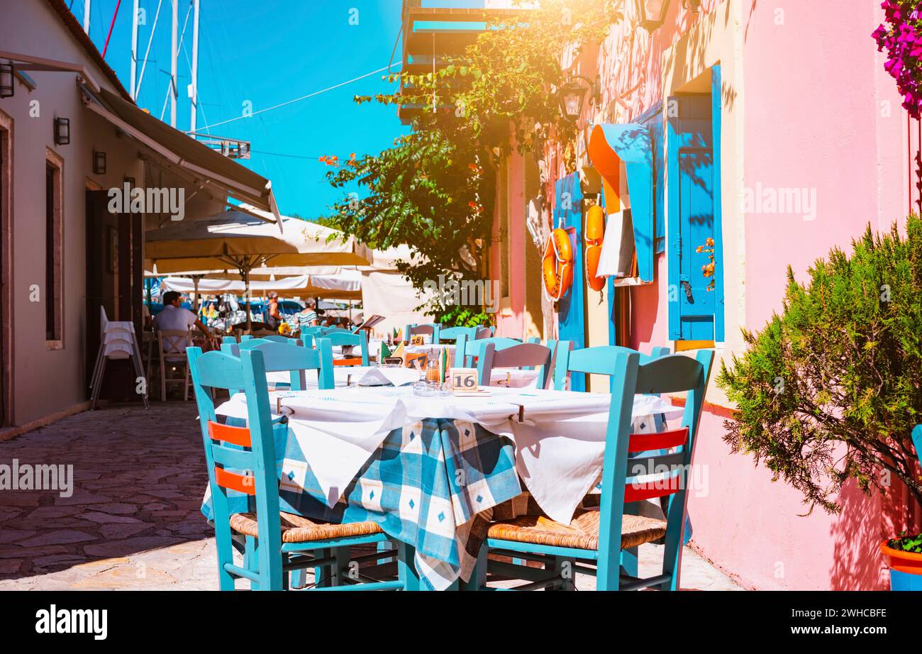 Traditionelle griechische Taverne lebendige Farben auf der schmalen Straße im Mittelmeerraum an heissen Sommertag. Stockfoto