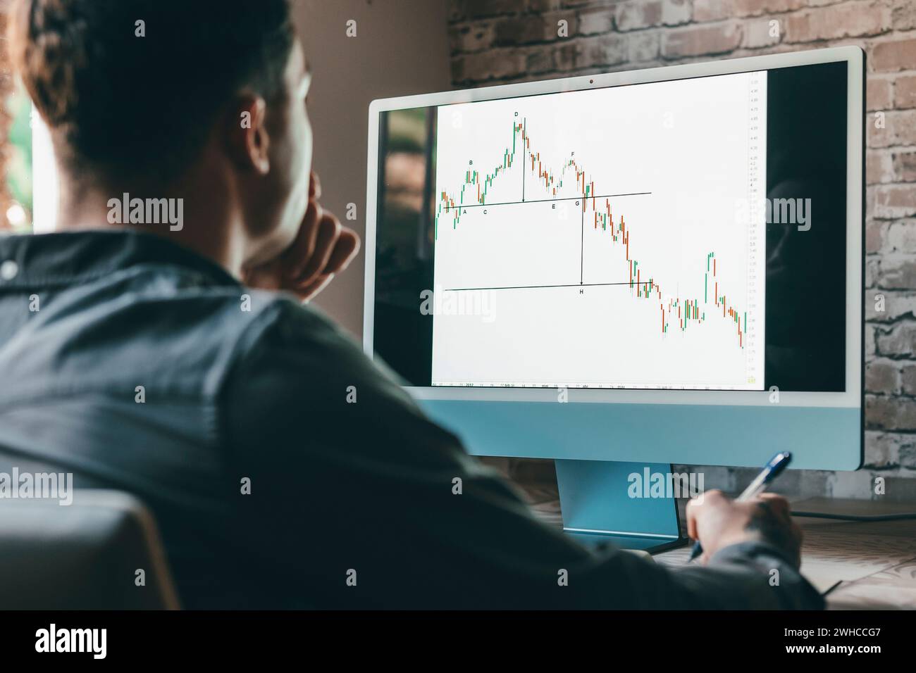 Kaukasischer Geschäftsmann Trader Investor Analyst, der sich mit Finanzbörsendiagrammen befasst, bewertet dynamische Handelsdatenindizes mit dem Wachstum von Mobiltelefonen und Laptops für die digitale Analyse von Kryptowährungen. Stockfoto