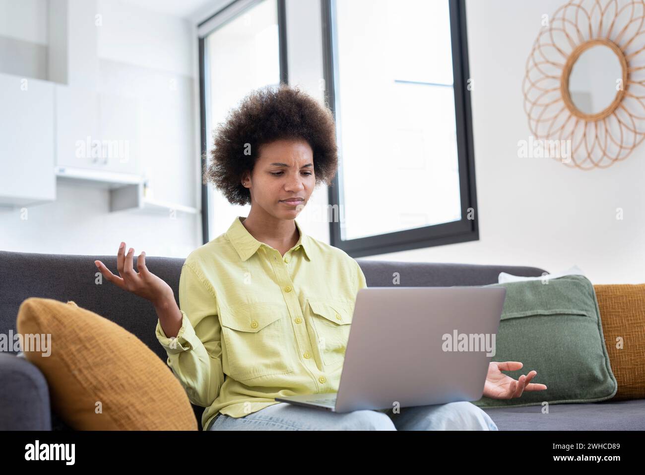 Frustrierte junge schwarze Hausbesitzerin, die E-Mails mit schlechten Nachrichten bekommt, am Laptop sitzt, am Rechner sitzt, Rechnungen zu Hause ausgibt, den Kopf berührt. Mädchen enttäuscht von überhöhten Ausgaben, hohe Gebühren Stockfoto