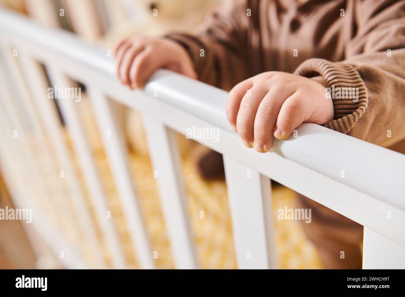 Winzige Hände eines kleinen Jungen, der im Kinderzimmer zu Hause im Kinderzimmer steht, Kind wächst in einer gemütlichen Wohnung Stockfoto