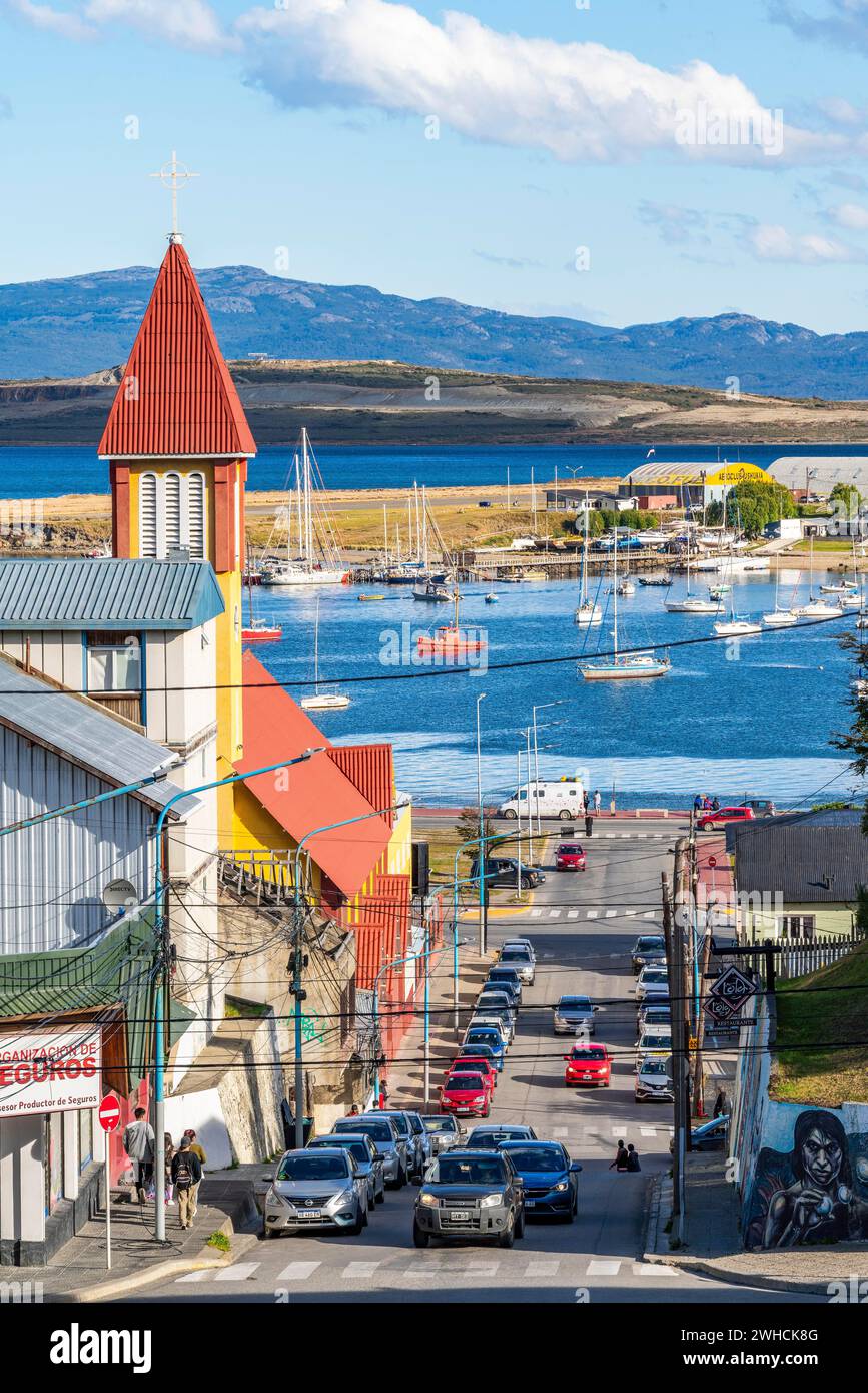 Gelb-rote Kirche in einer steilen Straße, Boote im Hafen am Beagle-Kanal, Ushuaia, Feuerland-Insel, Patagonien, Argentinien Stockfoto