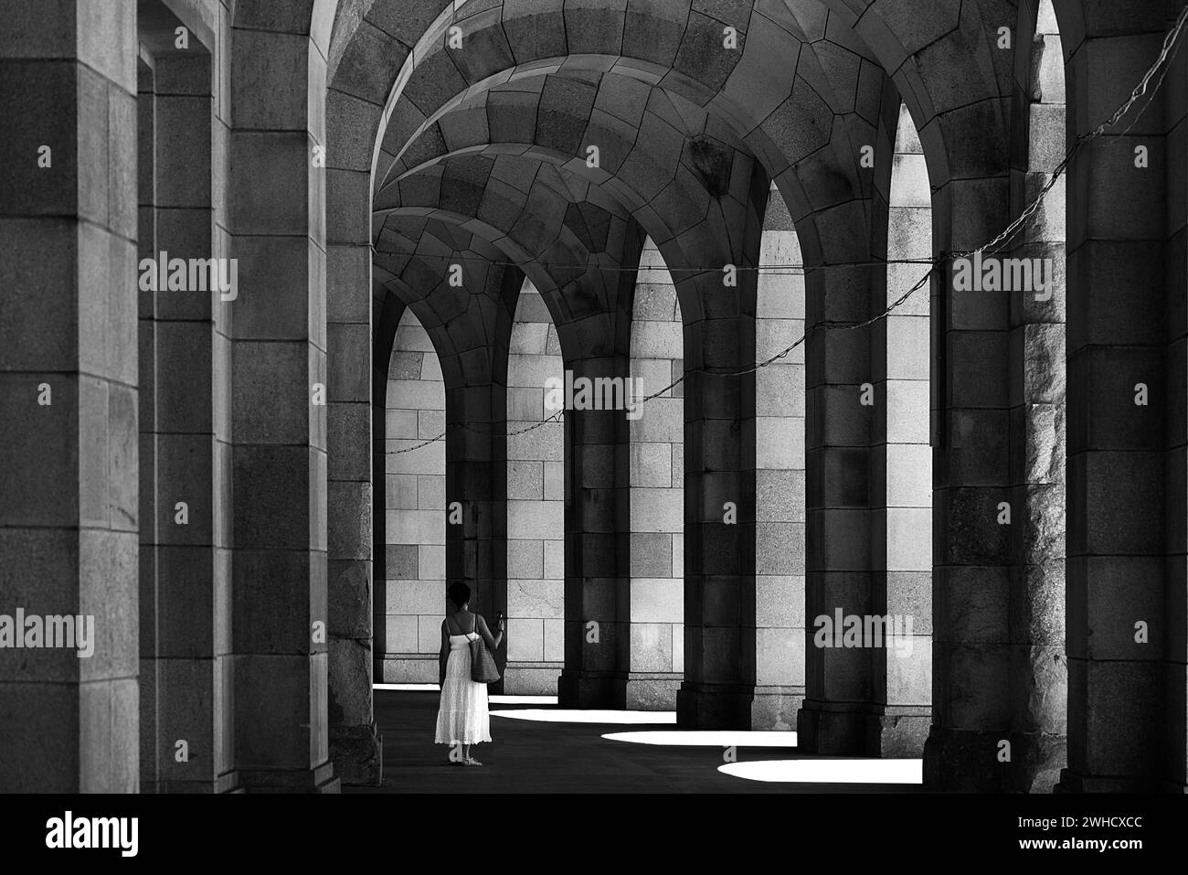 Dame in einem weißen Kleid in der Arkade der Kongresshalle, unvollendetes nationalsozialistisches monumentales Gebäude auf dem Gelände der Nazi-Partei-Rallye Stockfoto