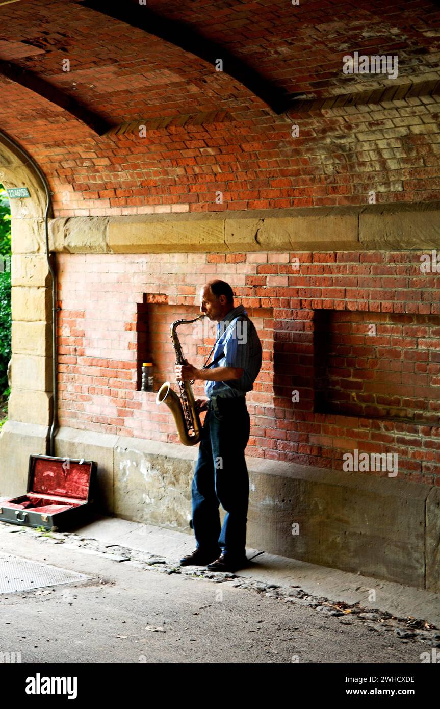 Saxophonspieler unter einer Brücke im Central Park, New York City, USA Stockfoto