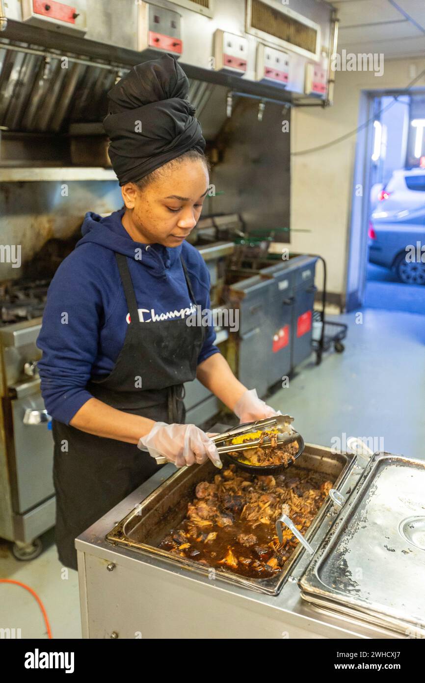 Detroit, Michigan: Natasha Coleman bereitet im Restaurant Yum Village Gerichte aus der Afro-Karibik zu. Stockfoto