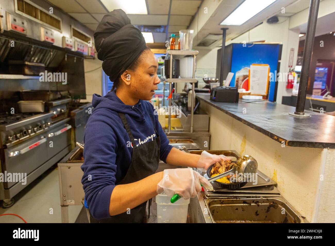 Detroit, Michigan: Natasha Coleman bereitet im Restaurant Yum Village Gerichte aus der Afro-Karibik zu. Stockfoto