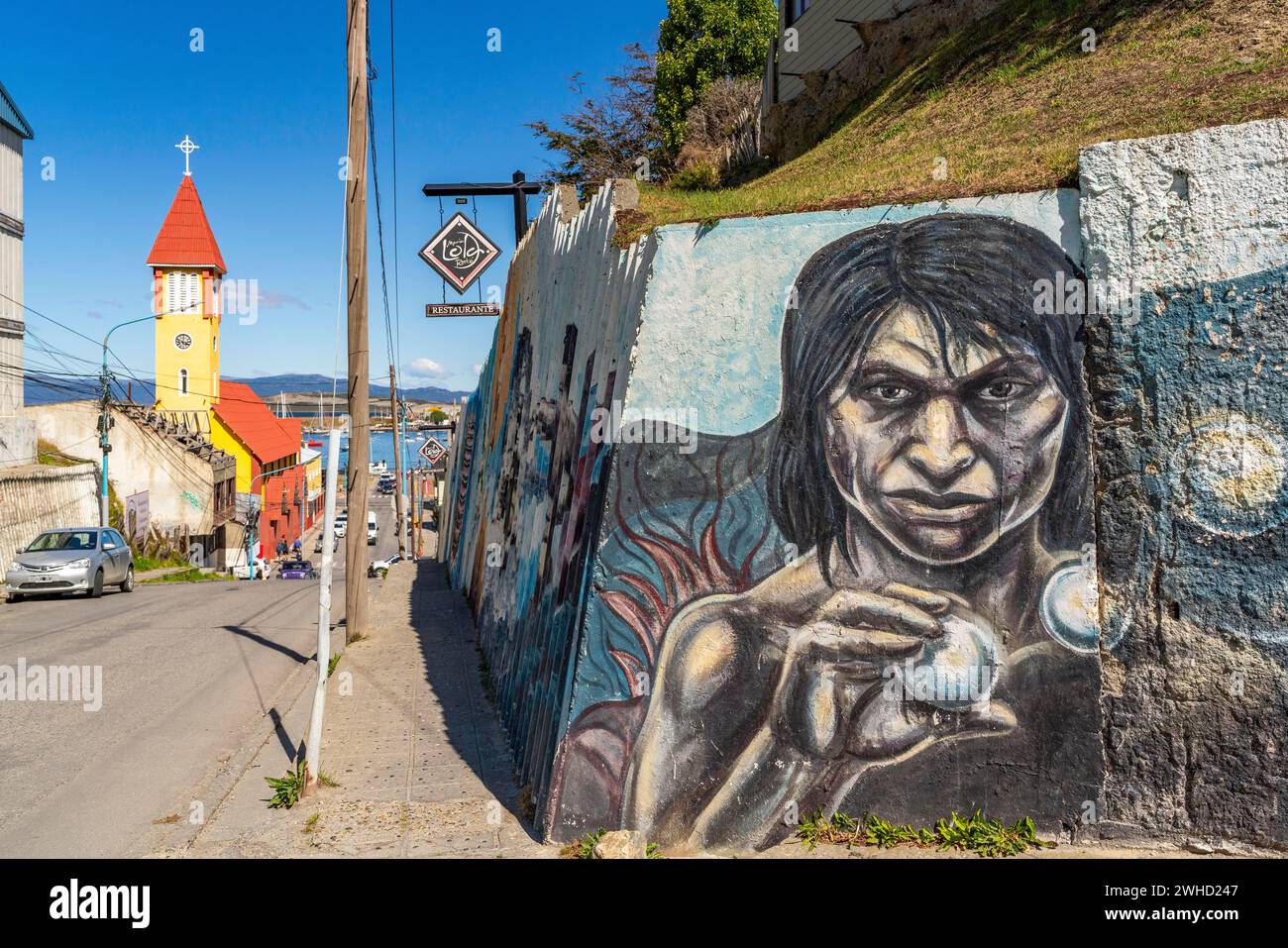 Mauer mit Street Art vor einer historischen, gelb-roten Kirche, Ushuaia, Feuerland Insel, Patagonien, Argentinien Stockfoto