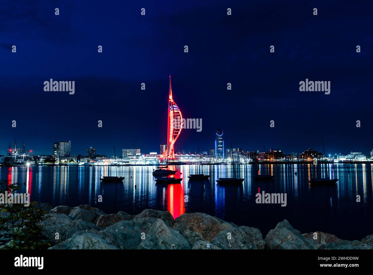 Skyline der Stadt Portsmouth in Großbritannien bei Nacht ist der Spinnaker Tower rot beleuchtet Stockfoto