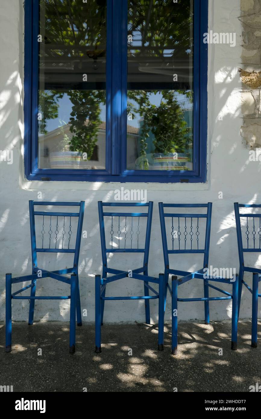 Griechenland, Parga, leere blaue Stühle ohne Sitzkissen, ein ruhiger Nachmittag Stockfoto