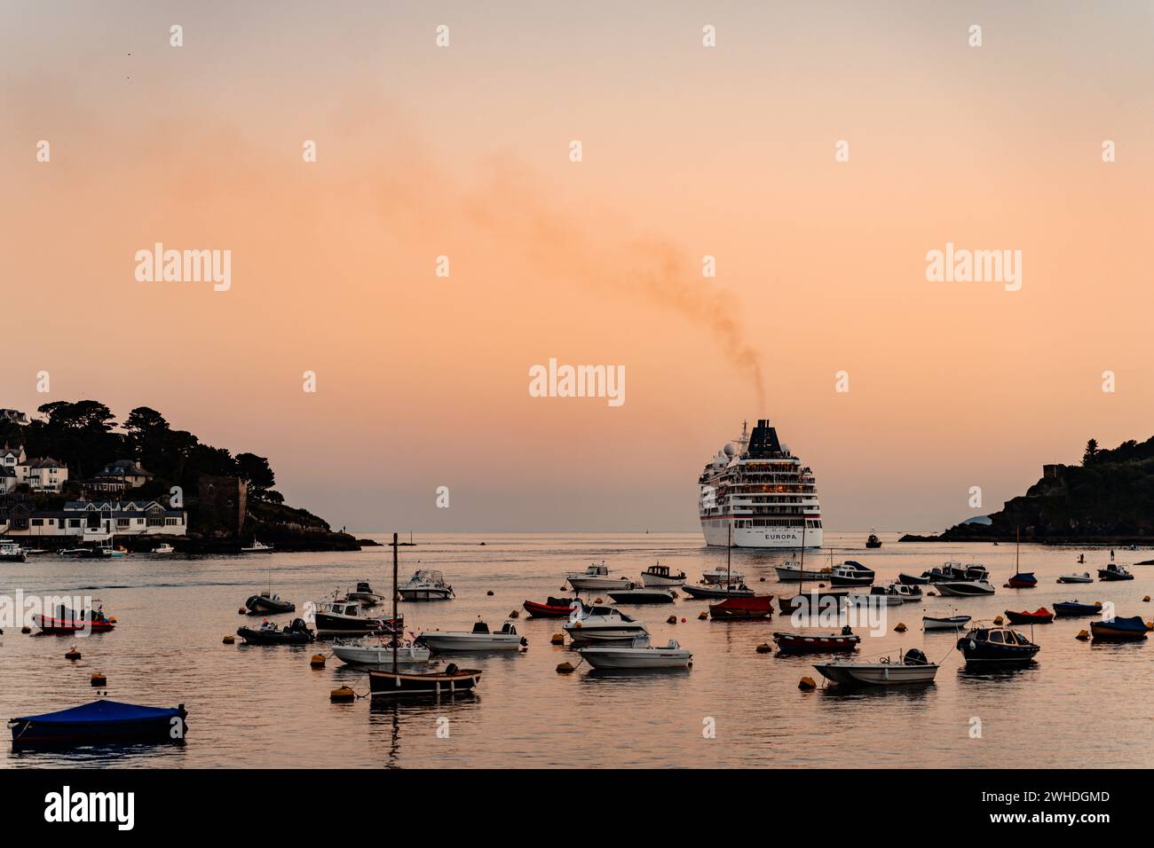 Das Kreuzfahrtschiff Europa verlässt den Hafen in Fowey Bay in Cornwall, Großbritannien an einem Abend im Sommer Stockfoto