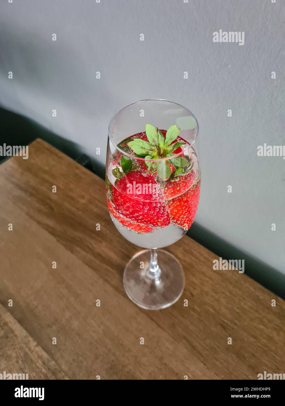 Frische rote Vollreife Erdbeeren mit Mineralwasser im Sektglas als alkoholfreies Erfrischungsgetränk im Sommer Stockfoto