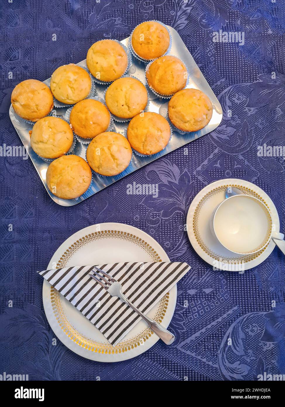 Tortenservice und silbernes Tablett mit Muffin auf einer blauen festlichen Tischdecke Stockfoto