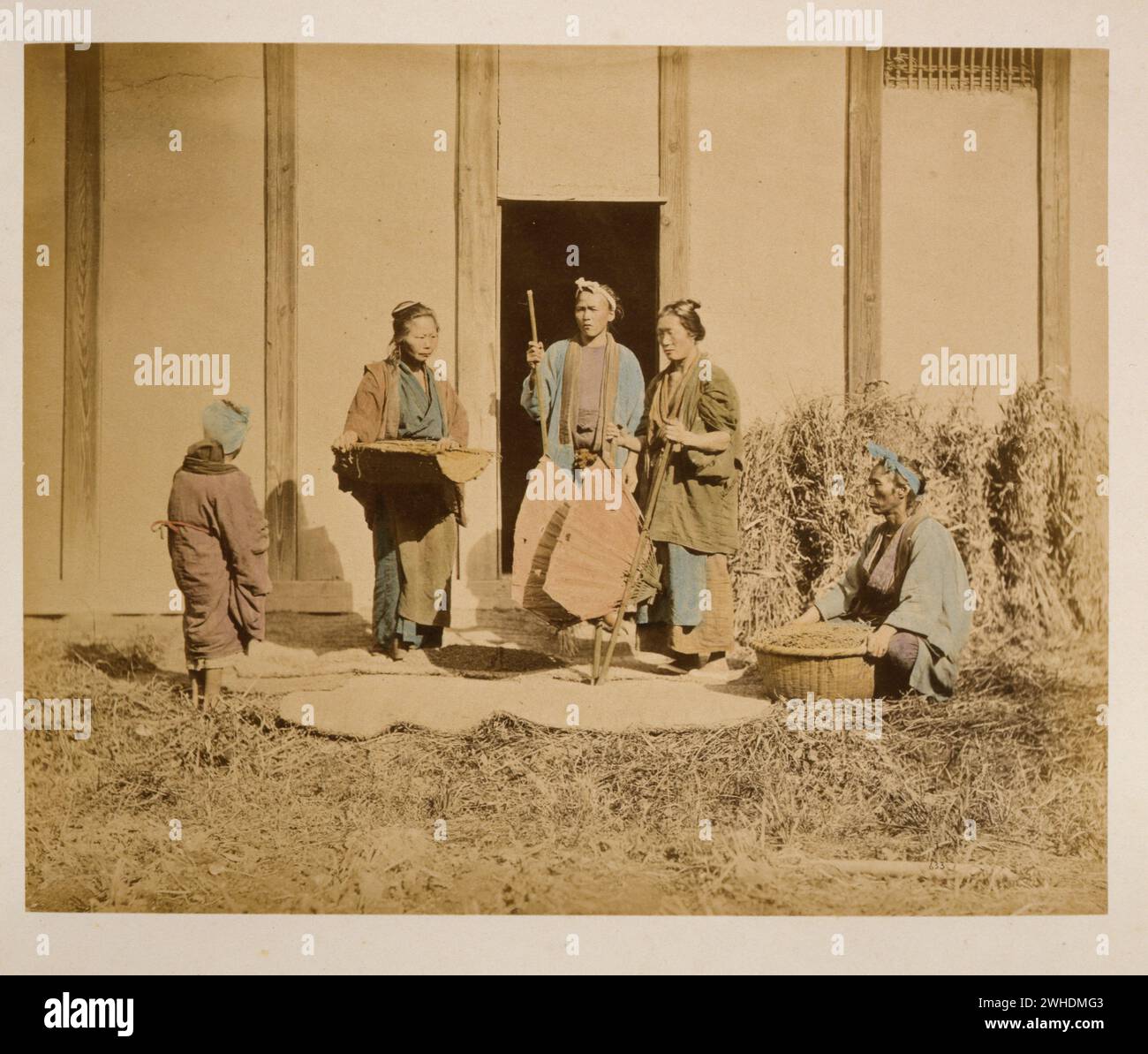 Eine Gruppe von Menschen, möglicherweise Straßenverkäufer oder Bauern, zwei Männer und zwei Frauen, zwei halten Körbe und eine Person mit Rücken zur Kamera... Japan handkoloriert mit Aquarell Fotografie Print um die 1870er Jahre Stockfoto