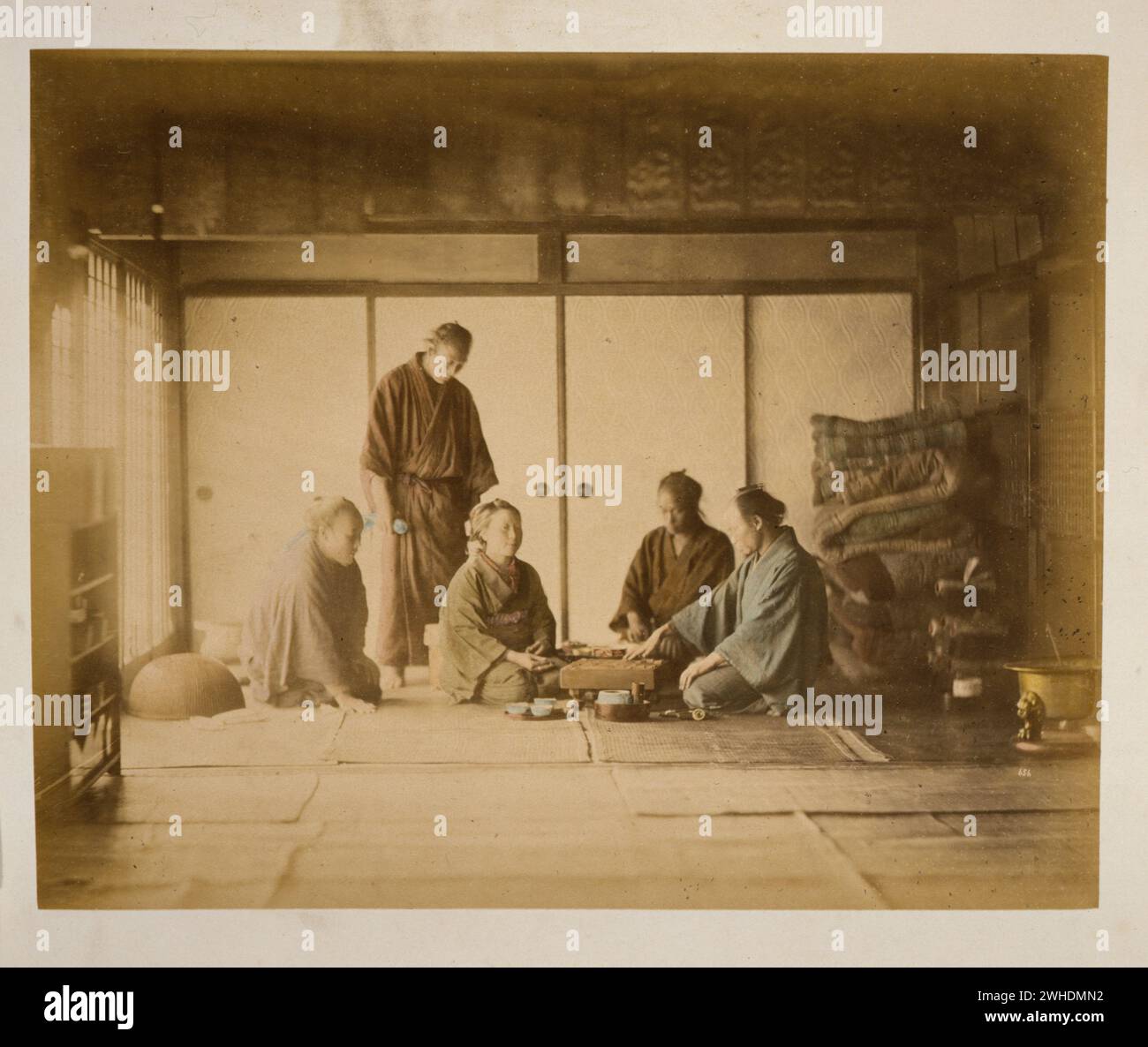 Innenansicht des Zimmers, in dem Männer und Frauen das Brettspiel 'Gositting on Tatami...Japan handkoloriert mit Aquarell-Fotografie um die 1870er Jahre spielen Stockfoto