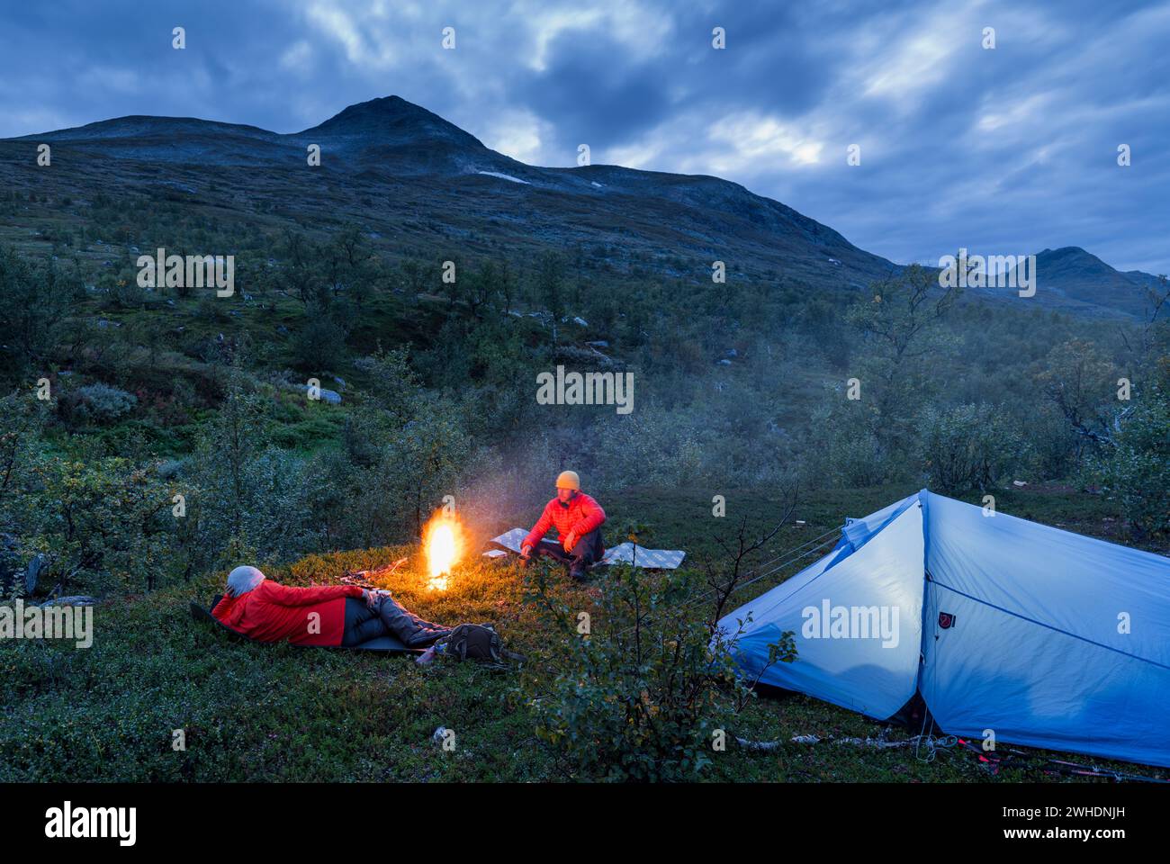 Zwei Wanderer rund um ein Lagerfeuer, ein Zelt, Hallji Berg, Stora Sjöfallets Nationalpark, Lappland, Schweden, Europa Stockfoto