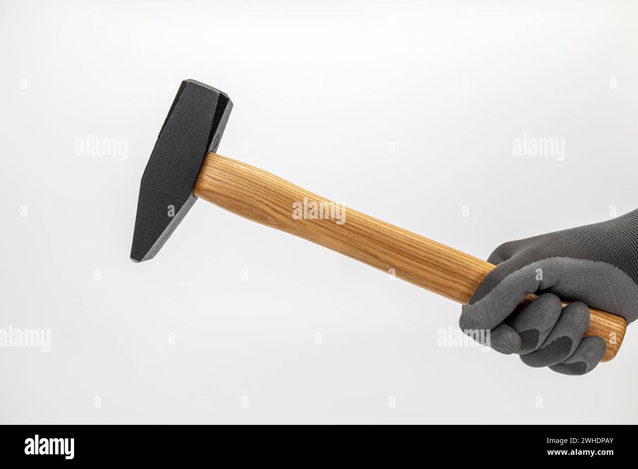Männerhand mit Arbeitshandschuh, der einen Schlosserhammer hält, weißer Hintergrund, Stockfoto