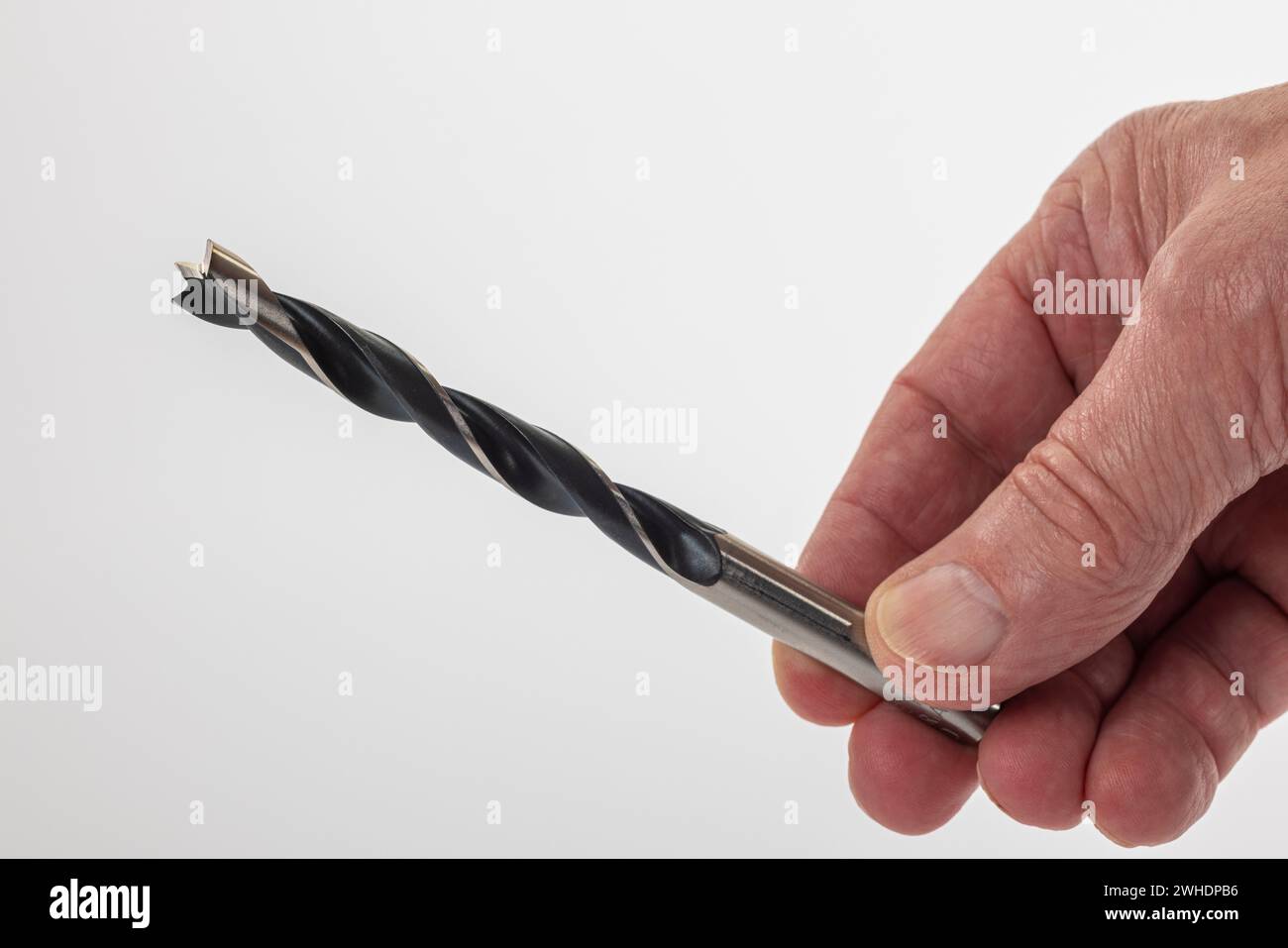 Mannshand hält 10 mm Holzbohrer, weißer Hintergrund, Stockfoto